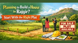 Planning to build a house in Rajgir – couple discussing a residential plot with a real estate agent near a “plot for sale” sign.